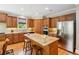 Spacious kitchen featuring center island with seating, stainless appliances, and hardwood floors at 11259 Calypso Dr, Alpharetta, GA 30009