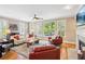 Bright living room featuring hardwood floors, fireplace, and large windows with plantation shutters at 11259 Calypso Dr, Alpharetta, GA 30009