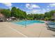 Community pool and lounge area surrounded by green trees under a partly cloudy sky at 11259 Calypso Dr, Alpharetta, GA 30009