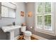 Elegant powder room with pedestal sink, modern fixtures, and bright window at 11259 Calypso Dr, Alpharetta, GA 30009