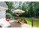 Backyard deck with seating, umbrella and view of a large wooded yard at 1418 Winborn Nw Cir, Kennesaw, GA 30152