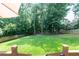 Expansive backyard featuring lush greenery, a playset, and mature trees, ideal for outdoor activities and recreation at 1418 Winborn Nw Cir, Kennesaw, GA 30152
