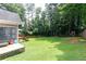 Spacious backyard featuring lush greenery, a playset, and mature trees, ideal for outdoor activities and recreation at 1418 Winborn Nw Cir, Kennesaw, GA 30152