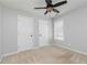 Neutral bedroom with two doors, ceiling fan, window, and neutral carpet at 1418 Winborn Nw Cir, Kennesaw, GA 30152