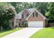 Charming brick home with a well-maintained lawn, driveway and classic architectural details at 1418 Winborn Nw Cir, Kennesaw, GA 30152