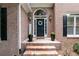 View of the entrance of a brick home with a wreath on the door and brick steps at 1418 Winborn Nw Cir, Kennesaw, GA 30152