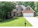 Beautiful brick home featuring a manicured lawn, mature trees and an attached two car garage at 1418 Winborn Nw Cir, Kennesaw, GA 30152