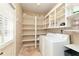 Functional laundry room with washer, dryer, storage shelves and natural light at 1418 Winborn Nw Cir, Kennesaw, GA 30152