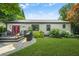 Home exterior with a spacious lawn, a patio with a grill, and vibrant landscaping beneath a blue sky at 2296 N Shallowford Rd, Atlanta, GA 30341
