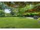 Expansive backyard with a lush lawn, mature trees, and an outdoor dining area, perfect for relaxation at 2296 N Shallowford Rd, Atlanta, GA 30341