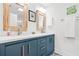 Bright bathroom featuring a double sink with blue cabinets, modern fixtures, and decorative mirrors at 2296 N Shallowford Rd, Atlanta, GA 30341
