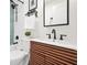 Stylish bathroom featuring a vanity with wood cabinets, a toilet, and a shower with modern, dark fixtures at 2296 N Shallowford Rd, Atlanta, GA 30341