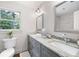 Bright bathroom with a double vanity, granite countertops, and an oversized decorative mirror at 3702 Running Fox Dr, Marietta, GA 30062
