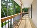 Inviting front porch featuring wood floors, a black railing, and a serene view of the lush surroundings at 3702 Running Fox Dr, Marietta, GA 30062