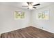 Bright bedroom featuring hardwood floors, a ceiling fan, and two large windows at 46 Cooper Lake Sw Rd, Mableton, GA 30126