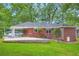 Back exterior view of red brick home with covered parking and a concrete patio at 739 Pinehill Se Dr, Smyrna, GA 30080