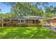 Charming brick home featuring a well-manicured lawn, a covered carport, and lush landscaping creating welcoming curb appeal at 739 Pinehill Se Dr, Smyrna, GA 30080