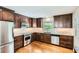 Updated kitchen features stainless steel appliances, granite countertops, dark wood cabinets, and hardwood flooring at 739 Pinehill Se Dr, Smyrna, GA 30080