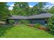 Beautiful shot of the home's exterior featuring a lush green lawn and lovely landscaping and garden at 11785 Mountain Laurel Dr, Roswell, GA 30075