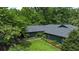 Aerial view showcases home with blue siding, dark roof, green lawn and mature shade trees at 11785 Mountain Laurel Dr, Roswell, GA 30075