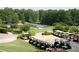 Neatly arranged golf carts near a scenic golf course with trees, a sand trap, and a tennis court at 11785 Mountain Laurel Dr, Roswell, GA 30075
