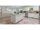 Bright kitchen features white cabinets, granite counters, stainless appliances, island, and beautiful tile floors at 11785 Mountain Laurel Dr, Roswell, GA 30075