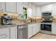 Updated kitchen with white cabinetry, stainless steel appliances, and granite countertops at 11785 Mountain Laurel Dr, Roswell, GA 30075