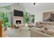 Bright living room featuring a fireplace, hardwood floors, and natural light from large windows at 11785 Mountain Laurel Dr, Roswell, GA 30075