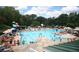 Outdoor pool area featuring a large swimming pool, lounge chairs, umbrellas, and a water slide for recreation at 11785 Mountain Laurel Dr, Roswell, GA 30075