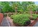 Lush backyard with landscaped garden beds, lighting, and mature trees, offering a serene outdoor retreat at 2412 Boulder Se Rd, Atlanta, GA 30316