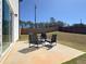 Relaxing backyard patio with stylish chairs and a view of the expansive, newly fenced yard at 301 Amsterdam Way, Hampton, GA 30228