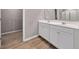 Elegant bathroom featuring a double sink vanity, wood-look floors and a walk in closet at 301 Amsterdam Way, Hampton, GA 30228