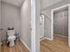 Well-lit bathroom with a toilet, shower, and view into a walk-in closet at 301 Amsterdam Way, Hampton, GA 30228