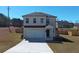 Charming two-story home with a well-maintained lawn, long driveway, and attached two-car garage at 301 Amsterdam Way, Hampton, GA 30228