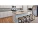 Modern kitchen features granite countertops, stainless steel appliances, and an island with seating at 301 Amsterdam Way, Hampton, GA 30228