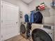The laundry room includes a washer, dryer, and shelving for storage at 301 Amsterdam Way, Hampton, GA 30228