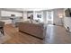 Open-concept living room features a large sofa, hardwood floors, and seamless access to the kitchen at 301 Amsterdam Way, Hampton, GA 30228