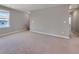 Spacious living room features neutral carpeting and paint at 301 Amsterdam Way, Hampton, GA 30228