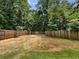 View of a fenced backyard with a well-maintained lawn, some bare areas, and a basketball court at 3517 Mortons Landing Dr, Ellenwood, GA 30294