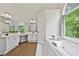 Bathroom featuring a tub under an arched window, a glass shower, and a double vanity at 4360 Canterbury Walk Dr, Duluth, GA 30097