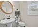Powder room featuring pedestal sink, round mirror, and window with blinds at 4360 Canterbury Walk Dr, Duluth, GA 30097