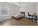 Simple bedroom with wood-look flooring, ceiling fan, and large windows at 4360 Canterbury Walk Dr, Duluth, GA 30097