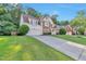 Beautiful home exterior featuring manicured lawn, long driveway, and traditional architecture at 4360 Canterbury Walk Dr, Duluth, GA 30097