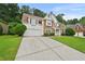 Beautiful home with stone details, a manicured lawn, and a long driveway leading to a two-car garage at 4360 Canterbury Walk Dr, Duluth, GA 30097