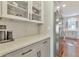 Close-up of kitchen featuring stainless steel refrigerator, white subway tile backsplash, and grey cabinetry at 4360 Canterbury Walk Dr, Duluth, GA 30097