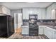 Functional kitchen features white cabinets, black appliances, and a connected dining area at 1417 Poplar Pointe Se, Smyrna, GA 30082