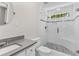 Bathroom features frameless glass shower, white tiles, gray vanity, and pebble-style shower floor at 1428 Brookcliff Dr, Marietta, GA 30062