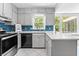 Bright kitchen featuring white cabinets, modern appliances, mosaic backsplash, and a large window with natural light at 1428 Brookcliff Dr, Marietta, GA 30062