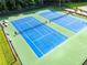 Aerial view of two professionally maintained, blue and green tennis courts for community enjoyment at 1428 Brookcliff Dr, Marietta, GA 30062