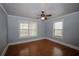 Cozy bedroom featuring wood-look tile flooring, ceiling fan, and ample natural light from two windows at 1852 E Farris Ave, Atlanta, GA 30344